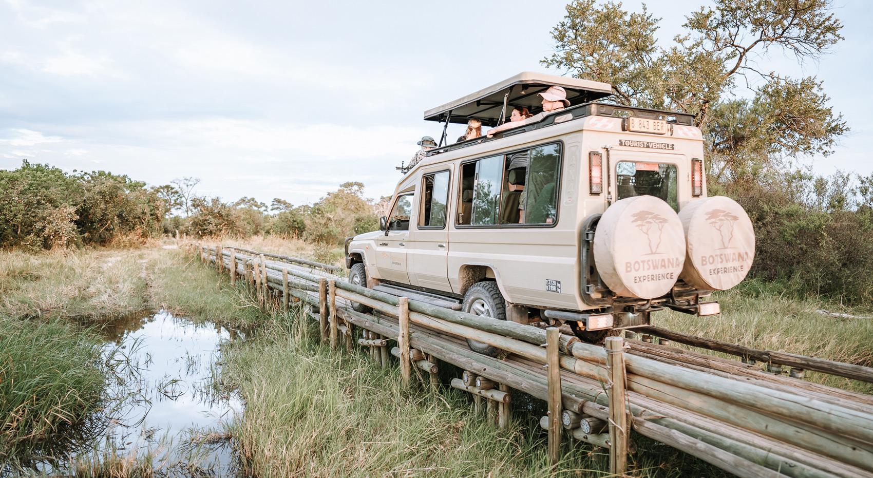 Ein Botswana-Experience Fahrzeug fährt über eine schmale Brücke. 