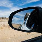 The side mirror of a 4x4 vehicle driving.