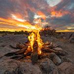 A campfire on Kubu Island with clouds in the sky.