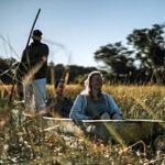 Reisende genießen eine Mokoro-Tour im Okavango Delta