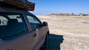 A self-driving vehicle is parked at Makgadikgadi Pan, facing Kubu Island.
