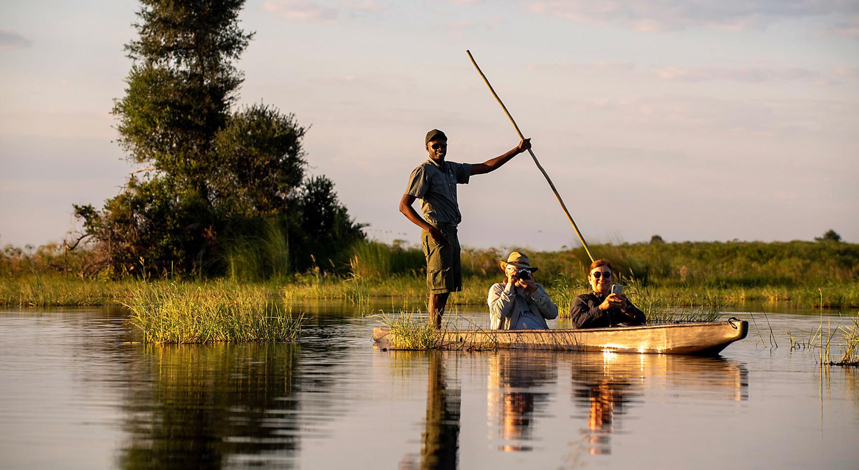 Gäste mit Guide in einem Mokoro im Okavango Delta. Gäste mit Guide in einem Mokoro im Okavango Delta.