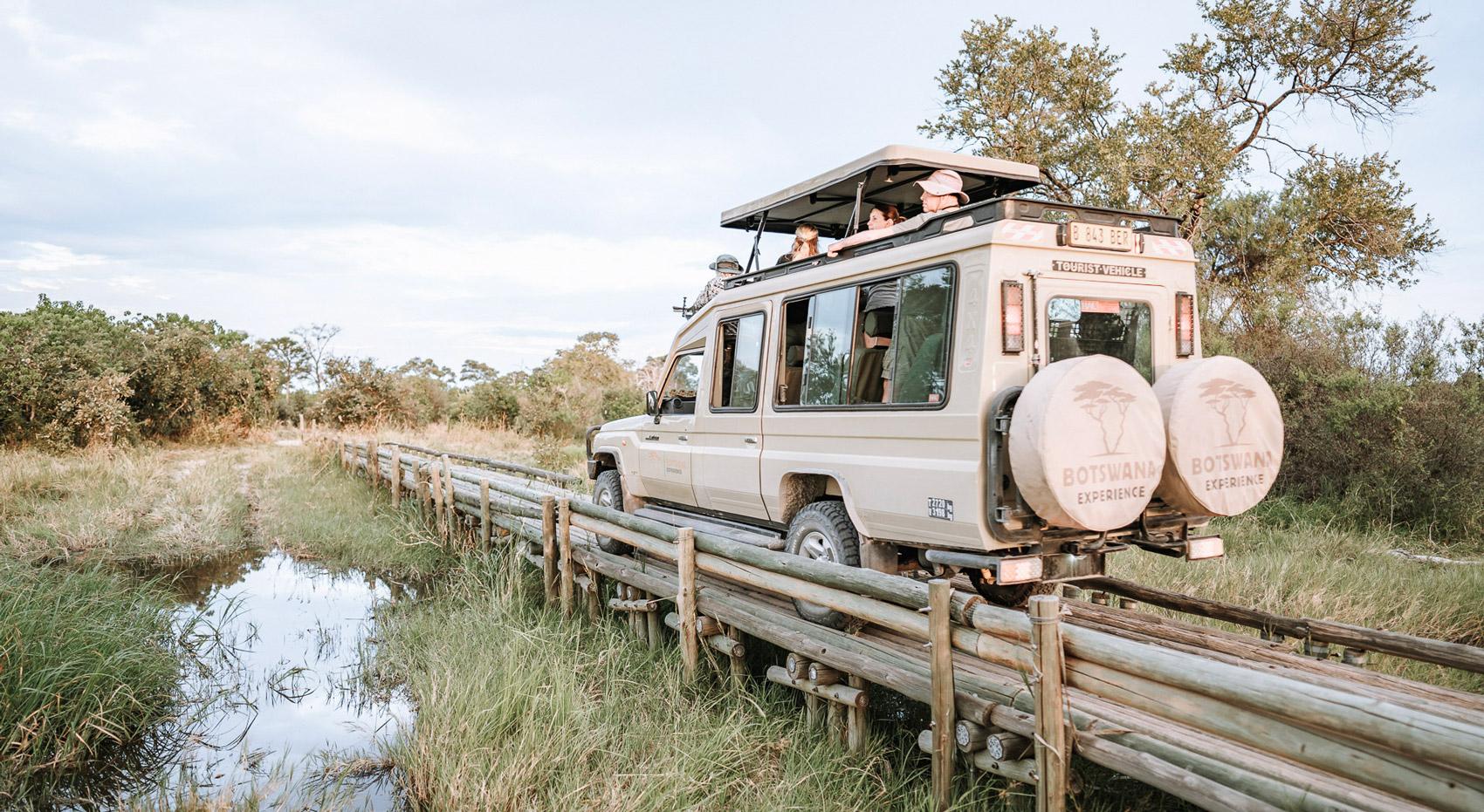 Ein Safarijahrzeug im Moremi Game Reserve fährt über eine Brücke. Ein Safarijahrzeug im Moremi Game Reserve fährt über eine Brücke.